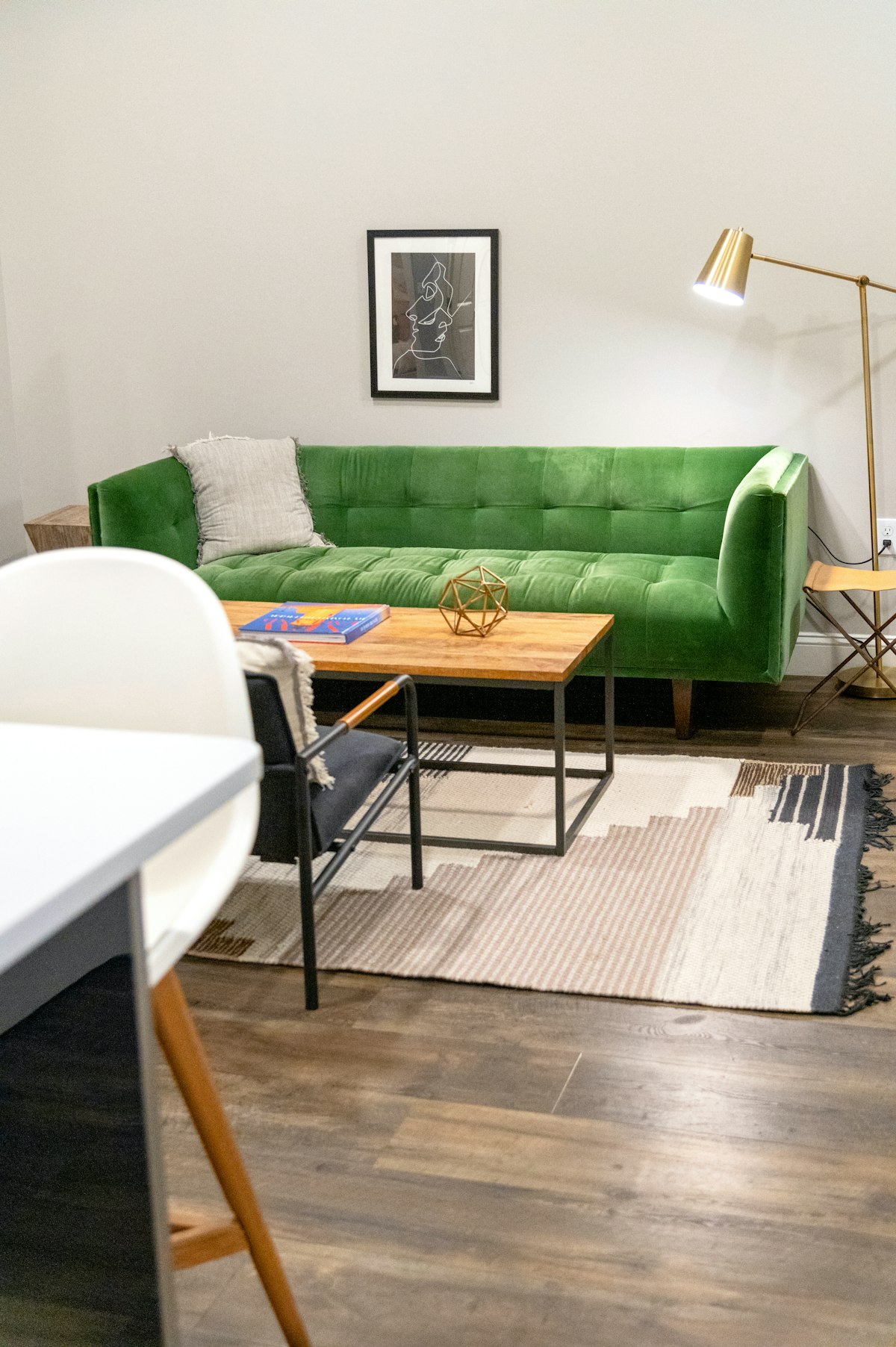 Lichtdurchfluteter Wohnraum mit sanften Wandfarben und einem grünen Sofa